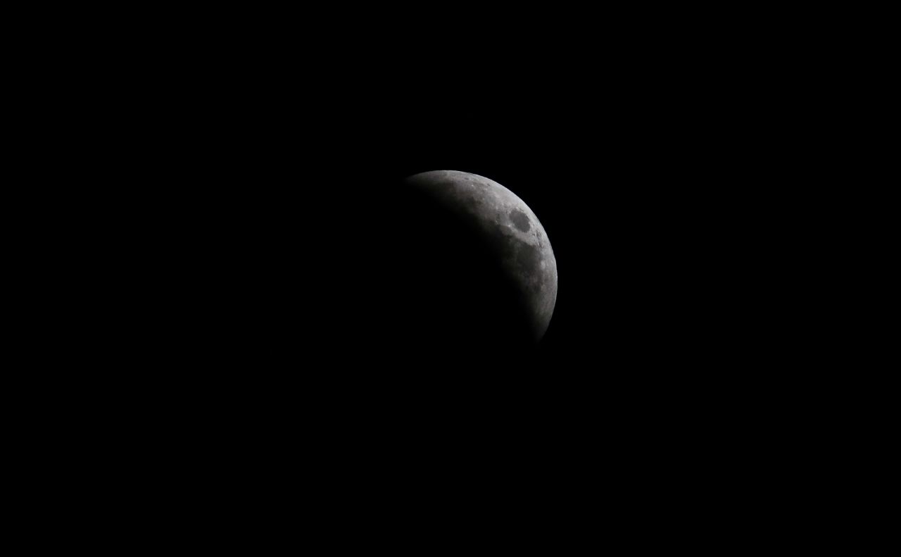 The moon is seen from Nicosia, Cyprus, as the eclipse began to become visible.
