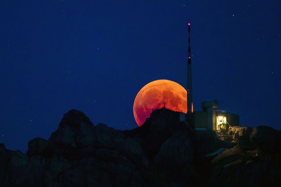 The blood moon is seen behind a mountain in Lucerne, Switzerland.