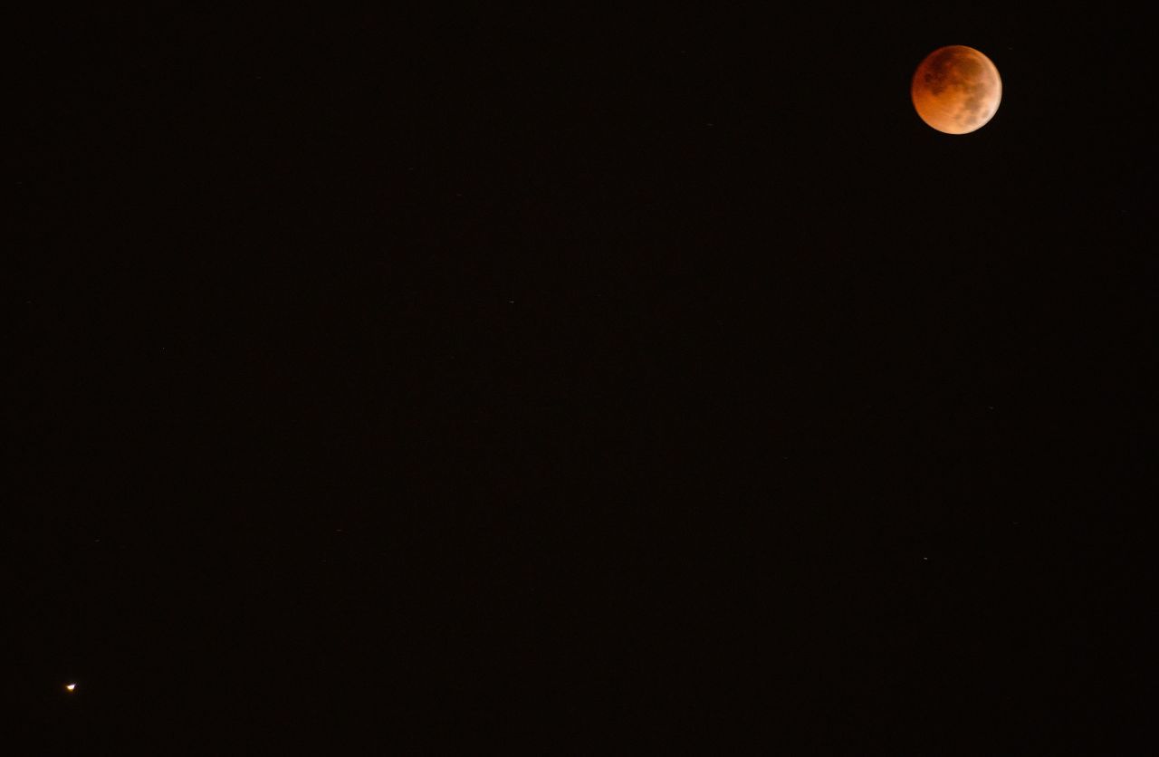 Joining the red moon in the sky Friday was the red planet Mars, as seen on the lower left of this photo taken in Islamabad, Pakistan. Mars is closer to Earth than it has been in 15 years.