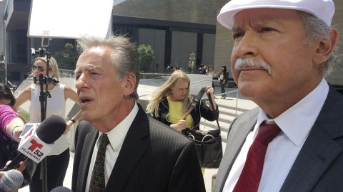 Attorneys Peter Schey, left, and Carlos Holguin field questions from reporters outside the federal courthouse in Los Angeles on Friday.