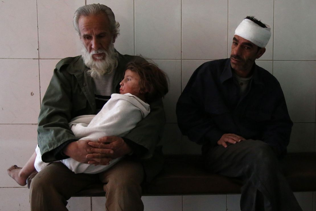 A man holds a wounded child at a hospital in Eastern Ghouta following airstrikes on November 15, 2017.