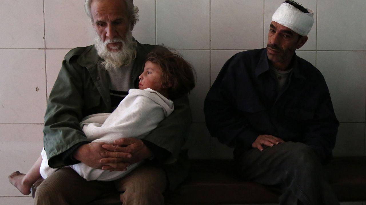 A man holds a wounded child at a hospital in Eastern Ghouta following airstrikes on November 15, 2017.