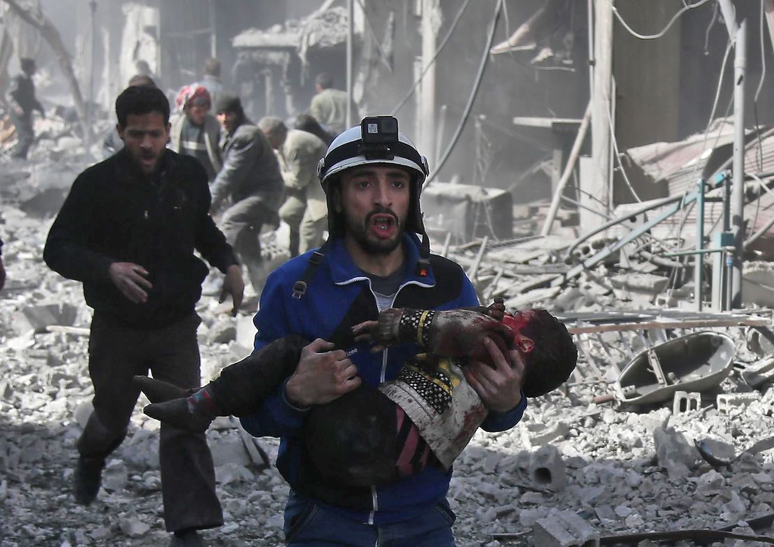 A member of the White Helmets volunteer rescue group carries an injured child after airstrikes in Eastern Ghouta on February 19.