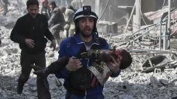 A Syrian civil defence member carries an injured child rescued from between the rubble of buildings following government bombing in the rebel-held town of Hamouria, in the besieged Eastern Ghouta region on the outskirts of the capital Damascus, on February 19, 2018.
Heavy Syrian bombardment killed 44 civilians in rebel-held Eastern Ghouta, as regime forces appeared to prepare for an imminent ground assault. / AFP PHOTO / ABDULMONAM EASSA        (Photo credit should read ABDULMONAM EASSA/AFP/Getty Images)