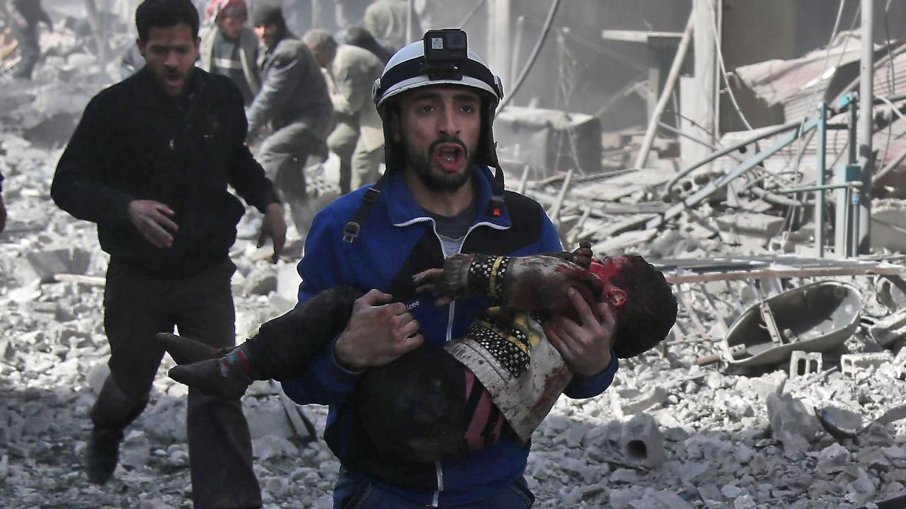 A member of the White Helmets volunteer rescue group carries an injured child after airstrikes in Eastern Ghouta on February 19.