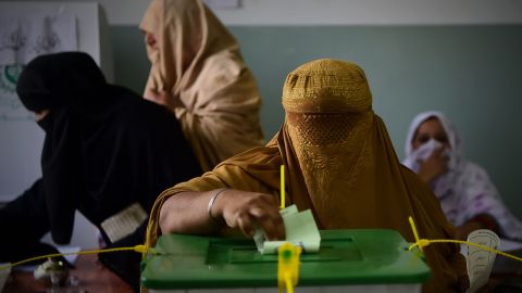 A burqa-clad woman casts her vote during Pakistan's general election at a polling station in Peshawar.