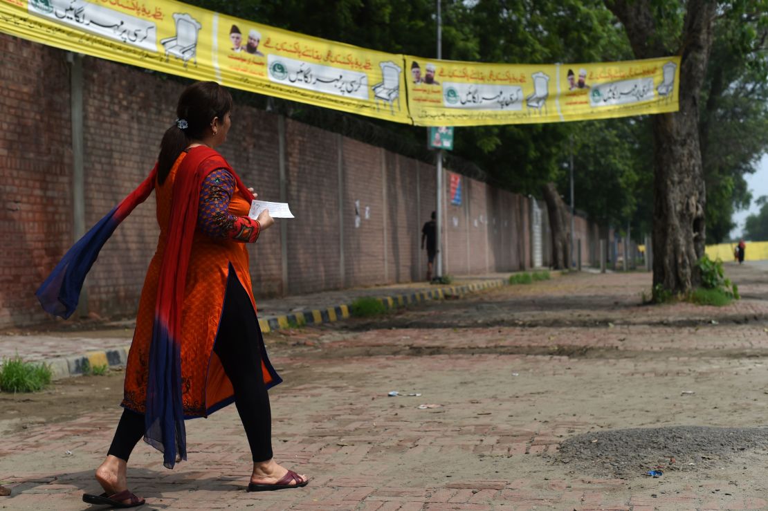 A Pakistani woman walks to cast her vote.