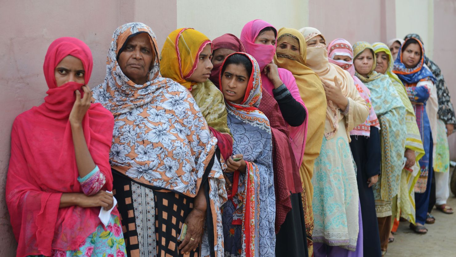 Pakistani women stand in a queue as they wait to cast their vote outside a polling station in Lahore.