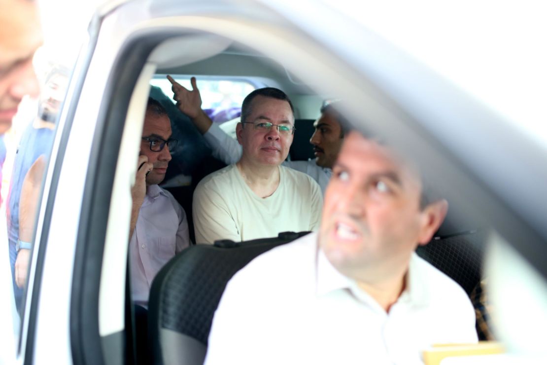 US Pastor Andrew Craig Brunson (C), is seen inside a car escorted by Turkish plainclothes police officers  as he arrives at his house last month.