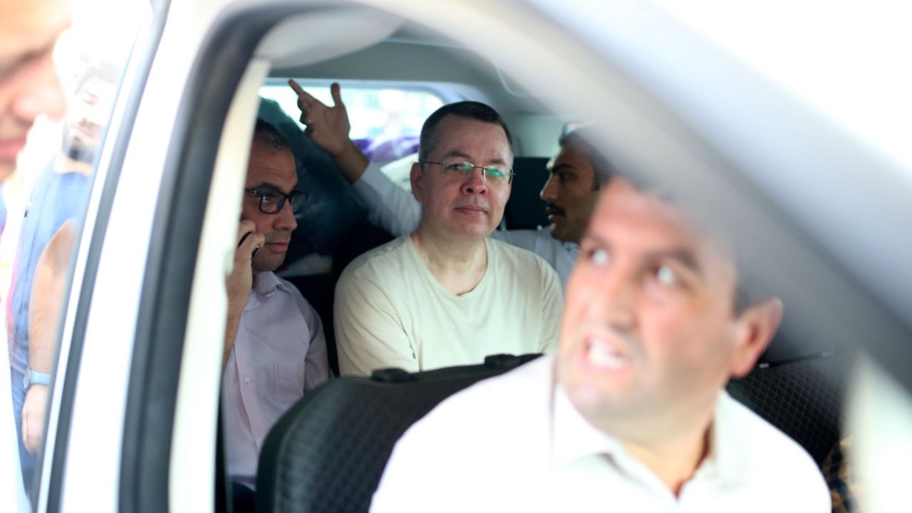 Andrew Brunson, center, is seen inside a car escorted by Turkish plain-clothes police officers as he arrives at his house in Izmir on July 25.
