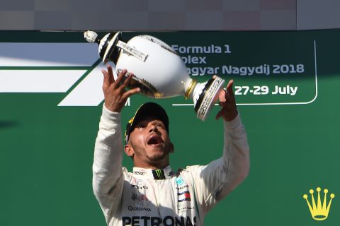 Lewis Hamilton celebrates with the trophy on the podium after winning the Hungarian Grand Prix at the Hungaroring near Budapest to extend his title lead over Sebastian Vettel to 24 points.