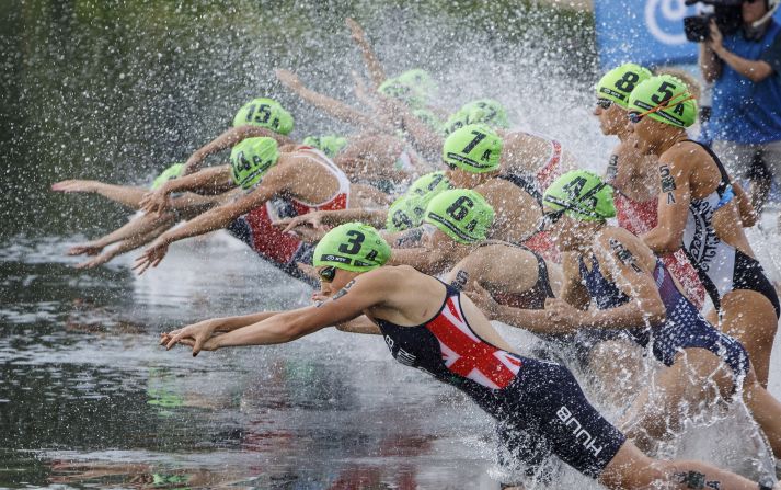 Competitors dive into the water during the mixed relay at the ITU World Triathlon Series in Edmonton, Alberta, on Saturday, July 28. 