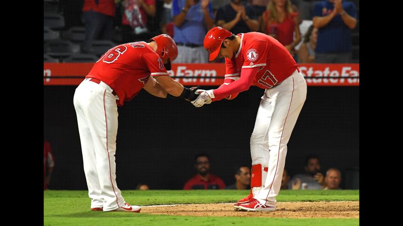 Kole Calhoun, No. 56 of the Los Angeles Angels of Anaheim, bows to Shohei Ohtani, No. 17 of the Los Angeles Angels of Anaheim, after he hit a two-run home run in the fifth inning against the Chicago White Sox at Angel Stadium on Wednesday, July 25, in Anaheim, California.   