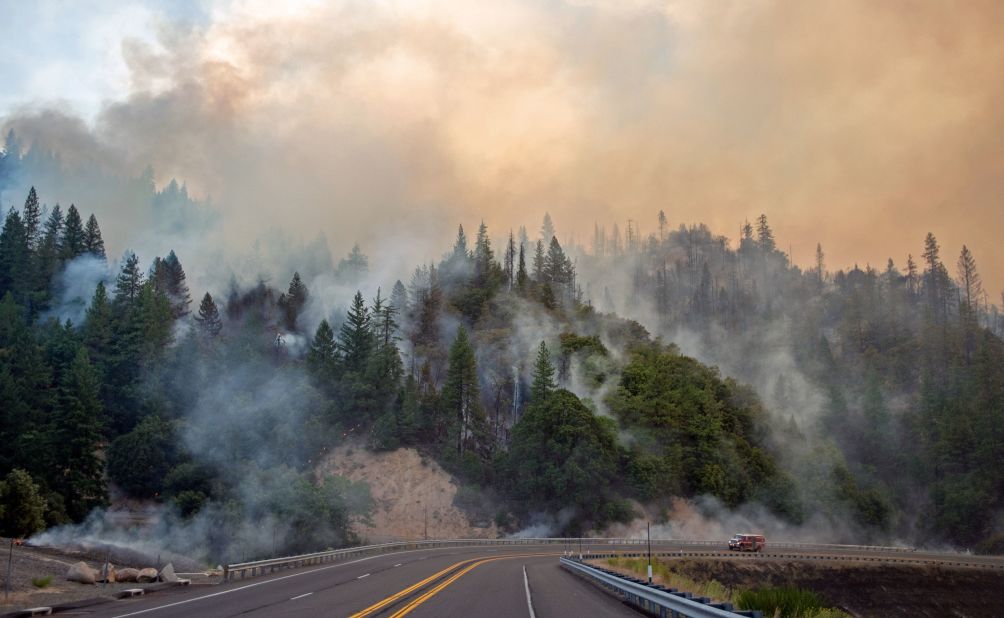 A fire truck drives along Highway 299 as the Carr fire continues to burn near Whiskeytown on July 28.