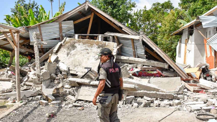 An Indonesian village security officer examines the remains of houses, after a 6.4 magnitude earthquake struck, in Lombok on July 29, 2018. - A powerful earthquake on the Indonesian tourist island of Lombok killed at least 10 people, injured dozens and damaged hundreds of homes on July 29, officials said. (Photo by Aulia AHMAD / AFP)        (Photo credit should read AULIA AHMAD/AFP/Getty Images)