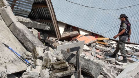An Indonesian village security officer examining the debris of houses, after a 6.4 magnitude earthquake struck, in Lombok on July 29.