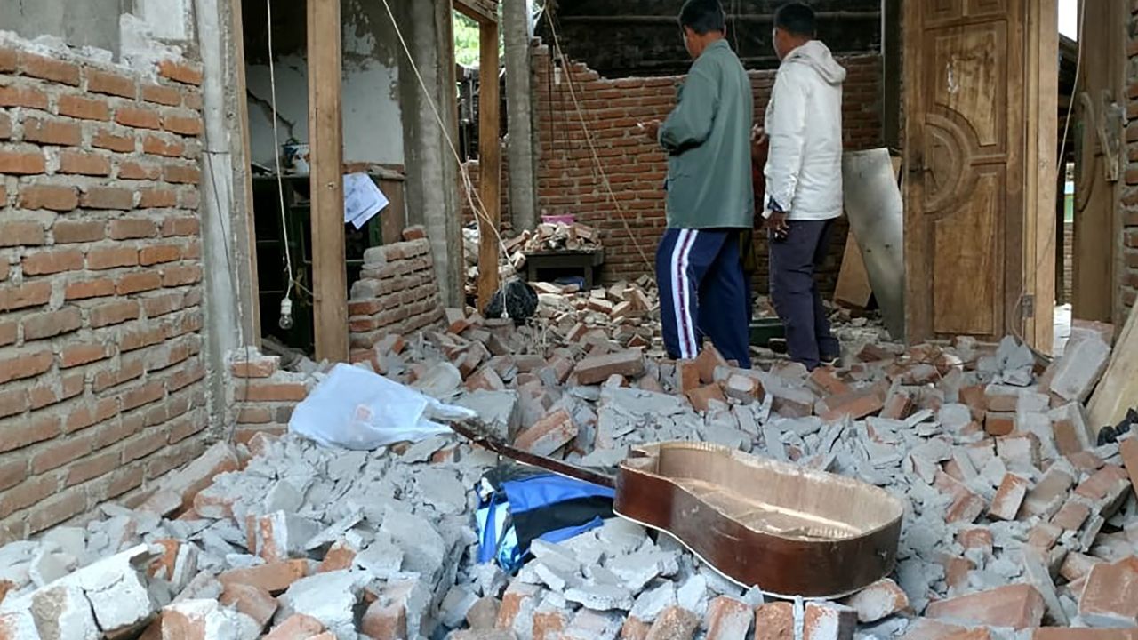Villagers walk through a house that was damaged after a 6.4 magnitude earthquake struck in Lombok on July 29.