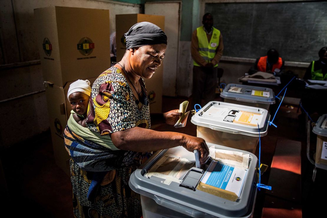A mother casts her ballot in a polling station in the capital, Harare.