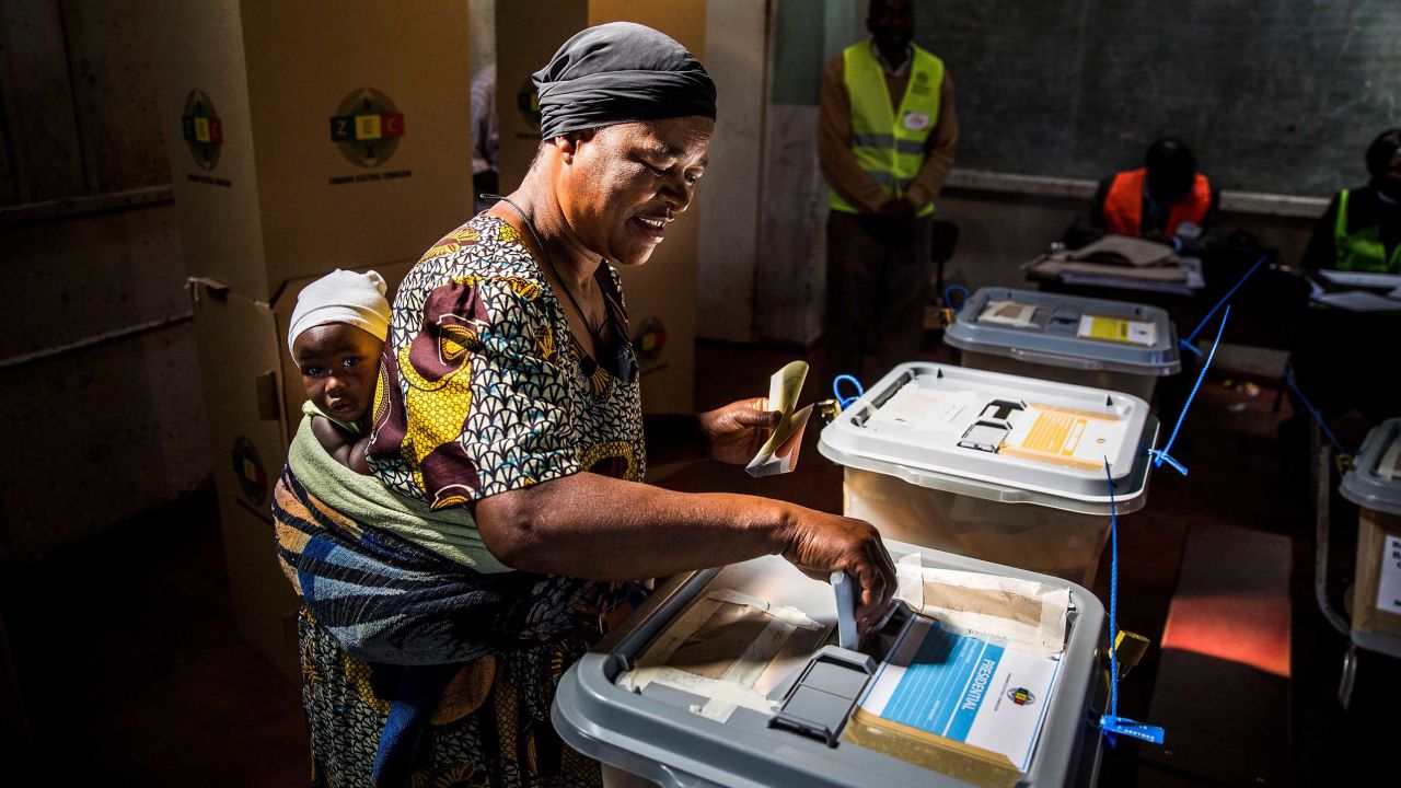 A mother casts her ballot in a polling station in the capital, Harare.