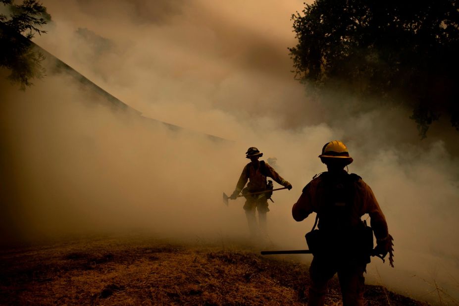 A firefighter walks through smoke while fighting to save a winery in Lakeport on July 30.