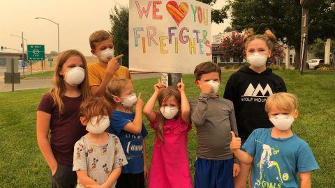 Nichole Grubbs-Miller and her sister's children handmade signs thanking firefighters for their service.