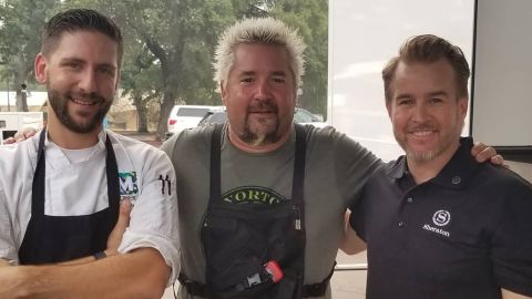 Guy Fieri (center) and Harrison (right) at an event that provided food for families displaced by the fire.