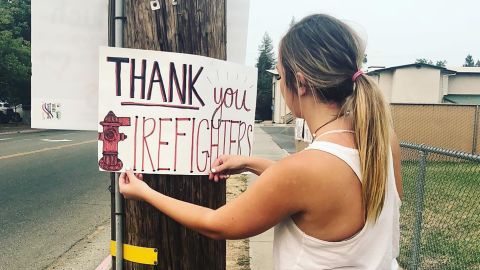 Root putting up a sign thanking the firefighters battling the Carr Fire.