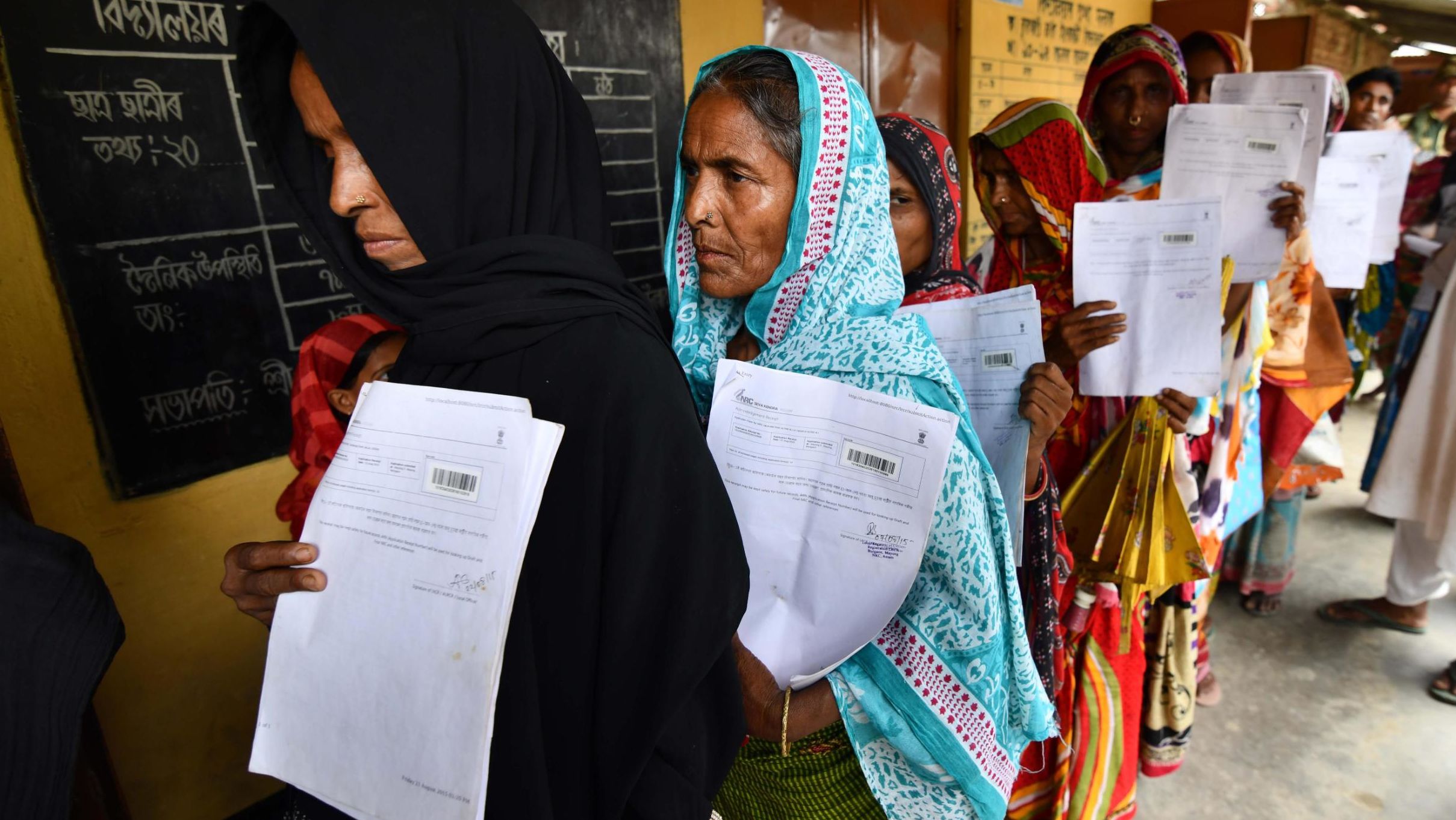 Residents hold their documents as they stand in a queue to check their names on the final list of National Register of Citizens (NRC) at a NRC Sewa Kendra (NSK) in Burgoan village in Morigoan district on Monday, July 30. 