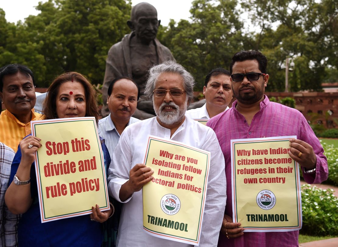 Indian lawmakers hold placards protesting against Assam's National Register of Citizens outside of Parliament in New Delhi on July 31, 2018. 