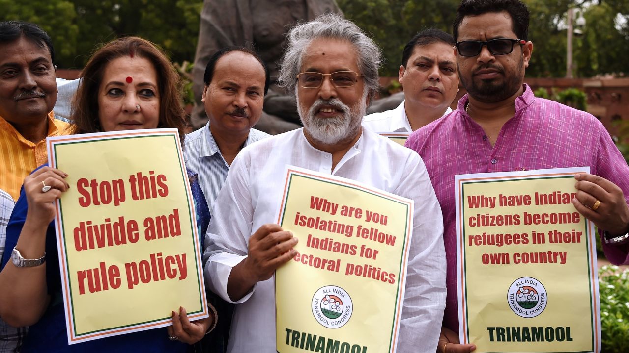 Indian lawmakers hold placards protesting against Assam's National Register of Citizens outside of Parliament in New Delhi on July 31, 2018.