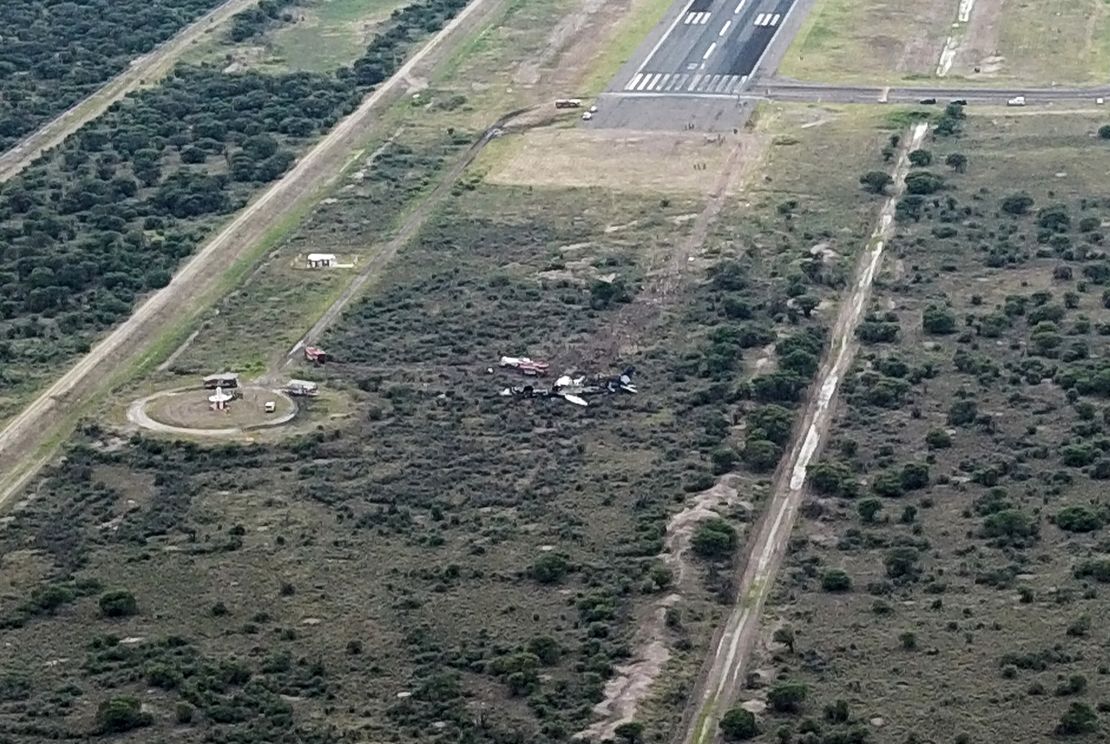 Rescue crews flock to the remains of the airplane just beyond the runway.