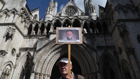 A supporter of Tommy Robinson is seen holding a placard outside the Royal Courts of Justice in London on Wednesday.