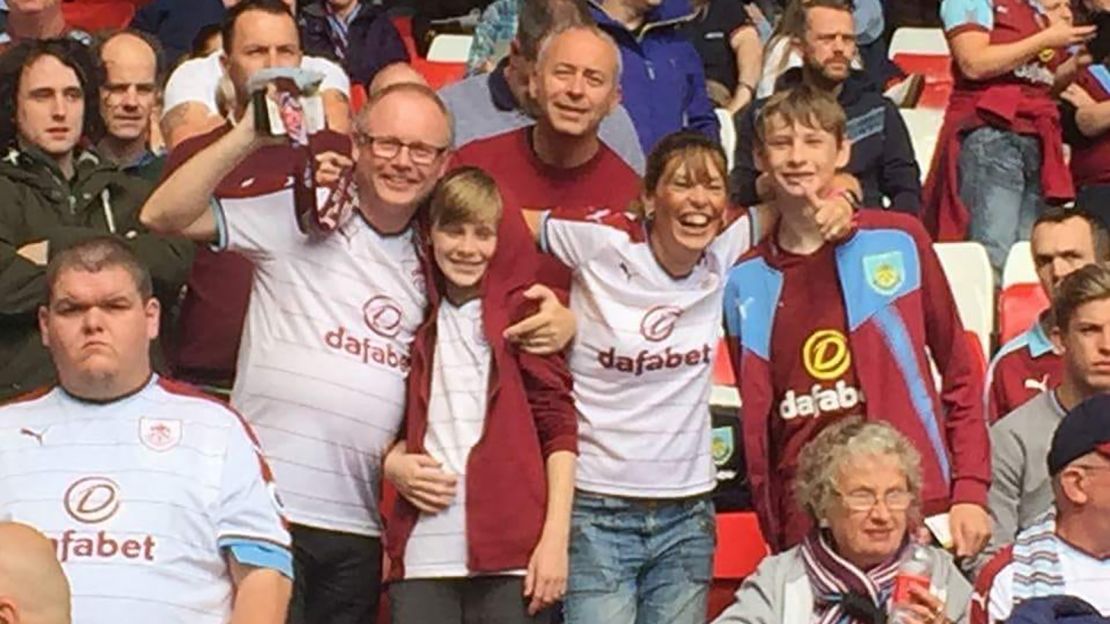Gail and Simon Astin watching Burnley at Anfield with their two sons last season.