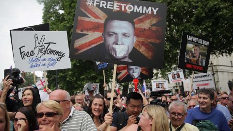 Protesters hold up placards at a gathering by supporters of far-right spokesman Tommy Robinson in central London on June 9, 2018.