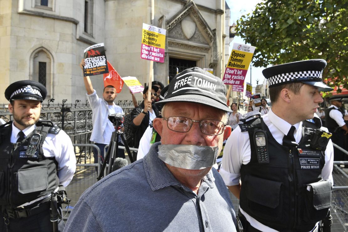 A supporter of Tommy Robinson poses for a photo as Stand Up to Racism demonstrators protest outside the court on Wednesday.