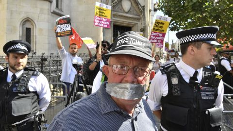 A supporter of Tommy Robinson poses for a photo as Stand Up to Racism demonstrators protest outside the court on Wednesday.