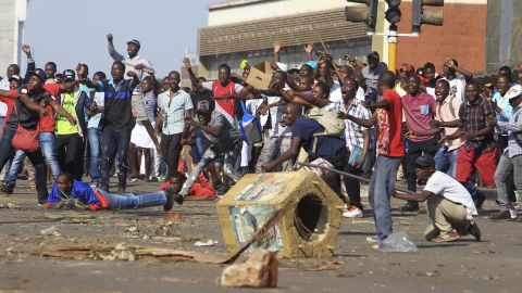 Opposition supporters react after police fire tear gas in Harare on Wednesday.