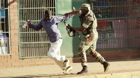 A Zimbabwean soldier beats a man in a street of Harare on Wednesday, August 1.