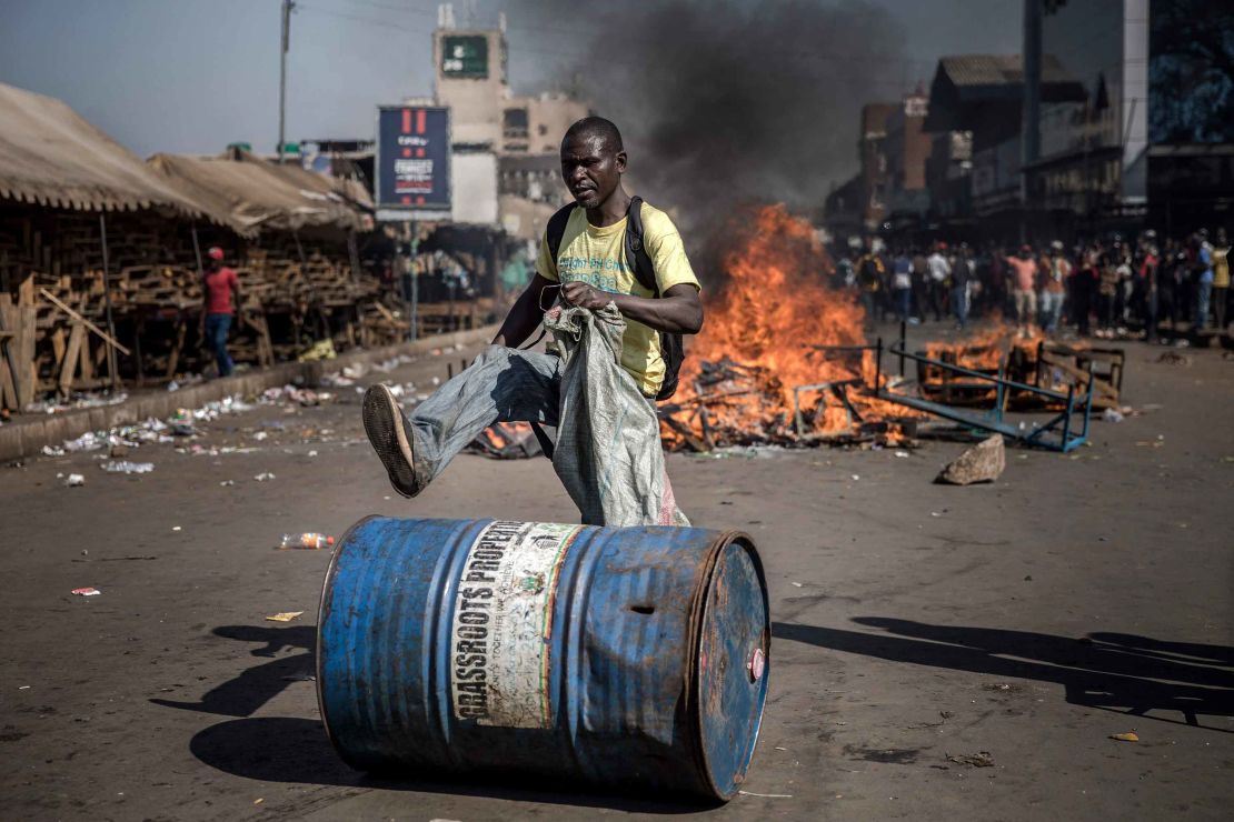 A supporter of the opposition pushes a barrel in front of a fire during a protest this week in Harare. 