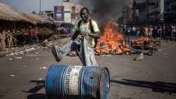 TOPSHOT - A supporter of Zimbabwean opposition MDC Alliance  push a barrel in front of a fire  in Harare on August 1, 2018, as protests erupted over alleged fraud in the country's election.Protests in Zimbabwe's historic elections turned bloody on August 1 as a man was shot dead during demonstrations over alleged vote fraud and the president appealed for calm. The man died after soldiers fired live ammunition during opposition protests in downtown Harare, AFP reporters saw. / AFP PHOTO / Luis TATOLUIS TATO/AFP/Getty Images