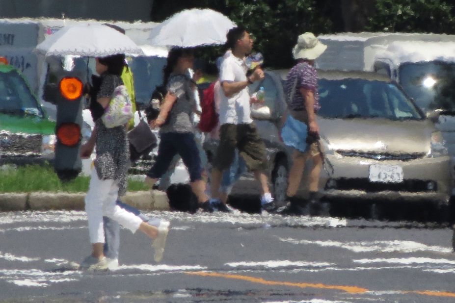 The effects of heat haze are seen in this photograph as pedestrians cross a street in Tokyo on Thursday, August 2.