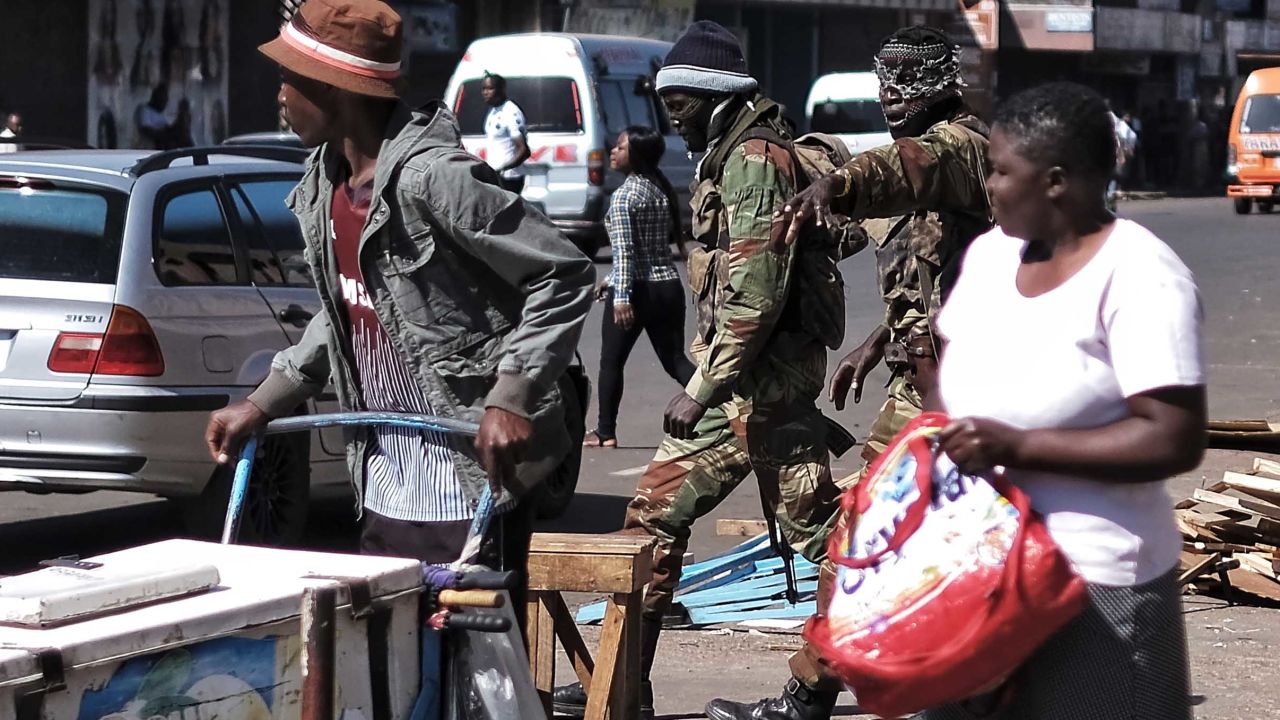 Soldiers in balaclavas shout orders to street vendors in Copacabana market Thursday.