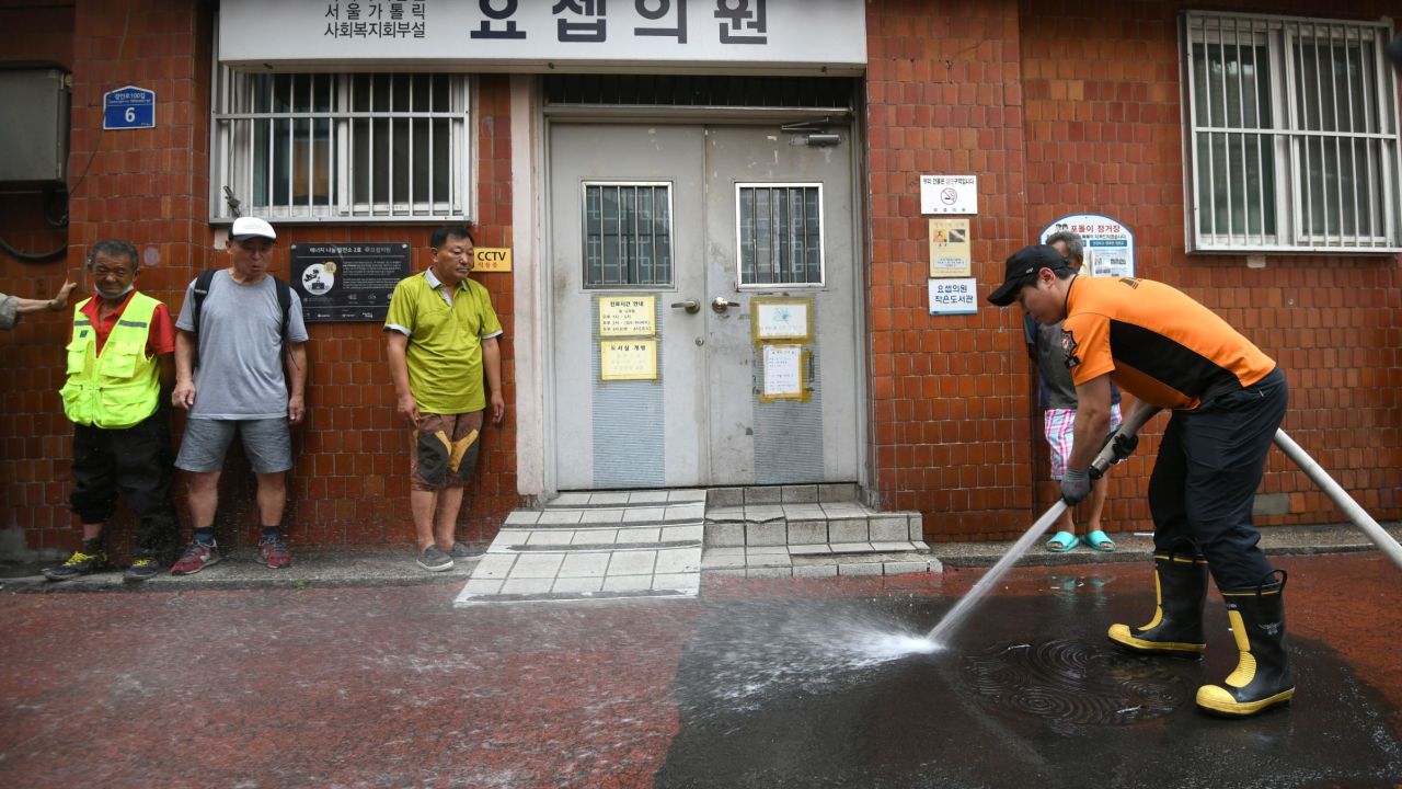 A firefighter sprays water in an alley of a residential district in Seoul to help ease the summer heat.