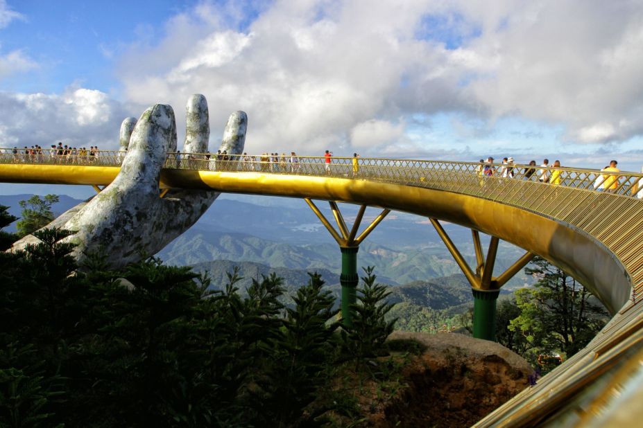 <strong>Day tripping: </strong>A pair of giant hands lift the ribbon-like Golden Bridge up in the air above Vietnam's Truong Son Mountains. The mind-bending structure, which towers above Thien Thai garden, looks like it's been there for centuries but just opened last year.