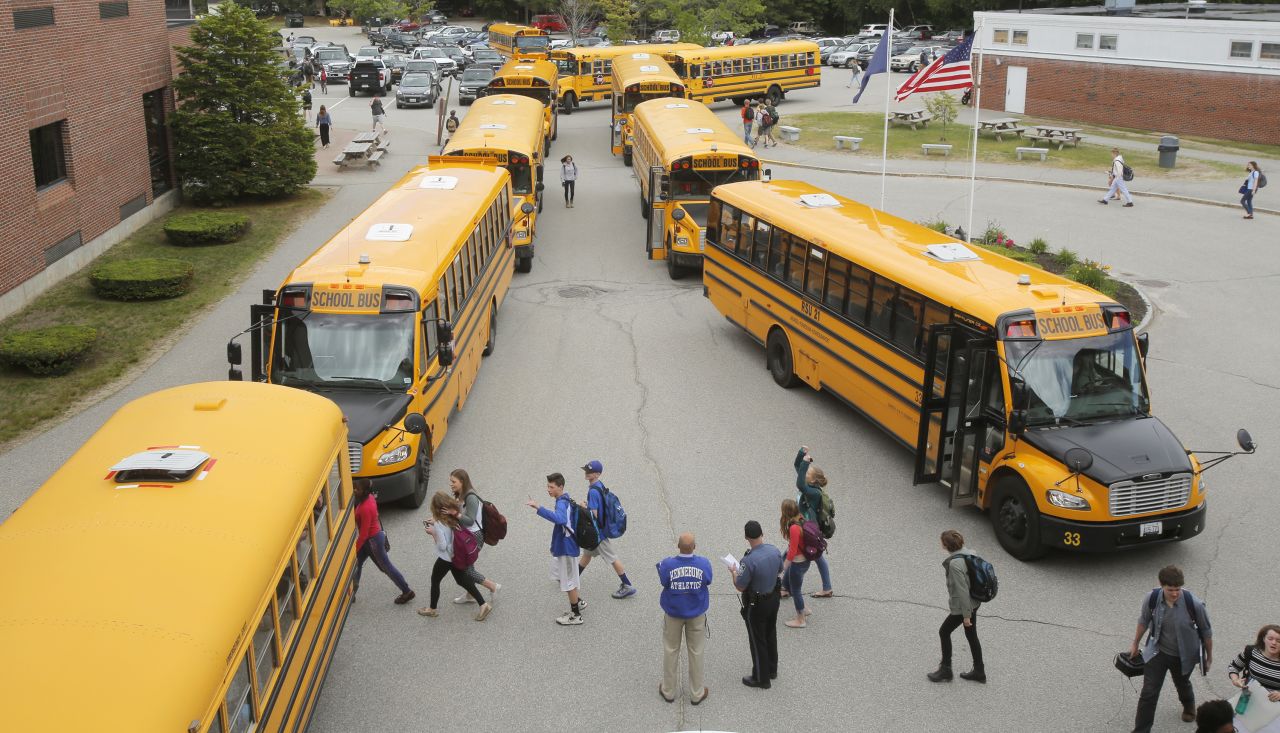 As classes let out, students walk to their respective buses, which will drive them home from Kennebunk High School in Maine in the United States.