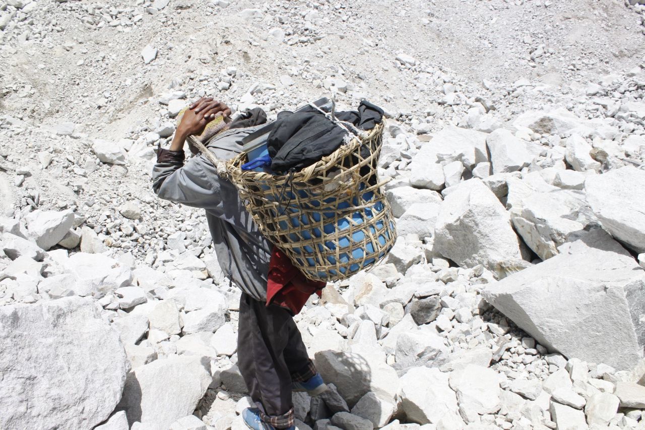Local porters working on Everest lug the barrels down from base camp to Gorak Shep, a frozen lakebed 17,000 feet above sea level.