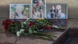 Flowers left in front of the photographs of Russian journalists (L-R) Alexander Rastorguyev, Kirill Radchenko and Orkhan Dzhema, killed in CAR