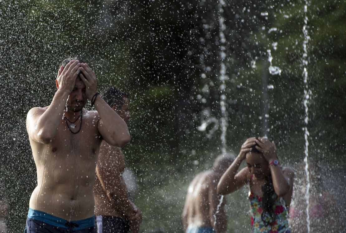 People cool off in a fountain in Madrid, during a scorching heat wave in 2018.