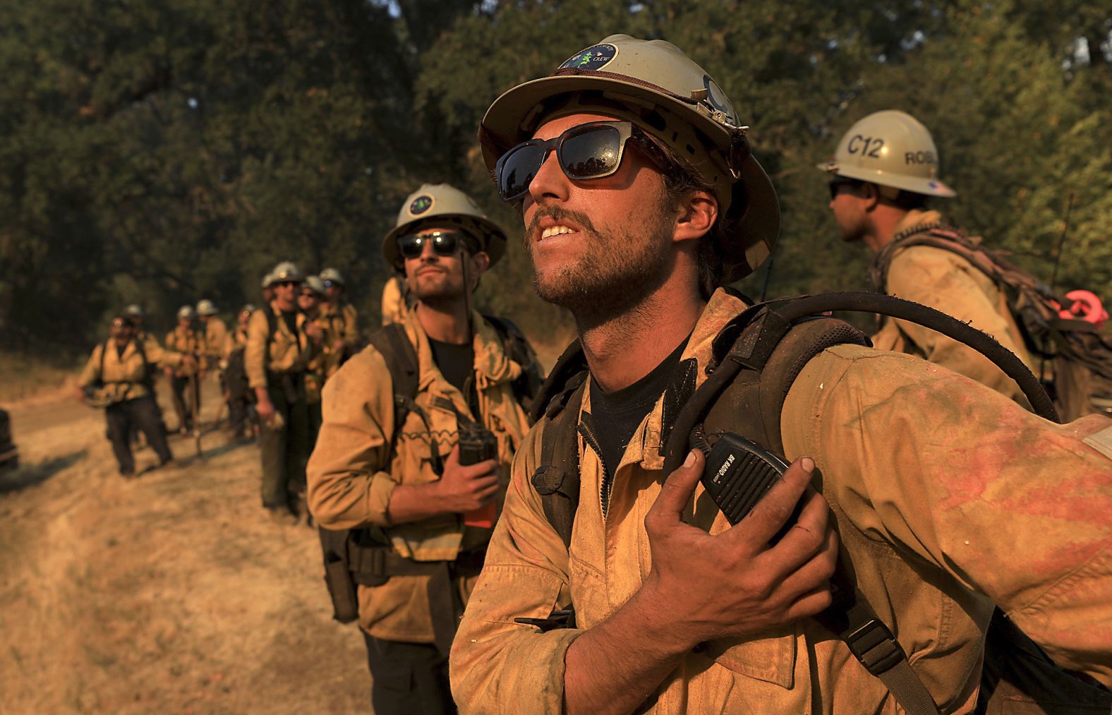 Ventura County firefighters watch as a helicopter makes a drop on a hot spot in Scotts Valley on August 3.