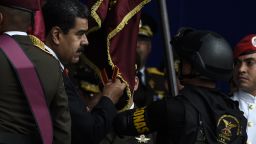 Venezuelan President Nicolas Maduro (L) attends a ceremony to celebrate the 81st anniversary of the National Guard in Caracas on August 4, 2018. - Maduro was unharmed after an exploding drone "attack", the minister of communication Jorge Rodriguez said following the incident, which saw uniformed military members break ranks and scatter after a loud bang interrupted the leader's remarks and caused him to look to the sky, according to images broadcast on state television. (Photo by Juan BARRETO / AFP)        (Photo credit should read JUAN BARRETO/AFP/Getty Images)